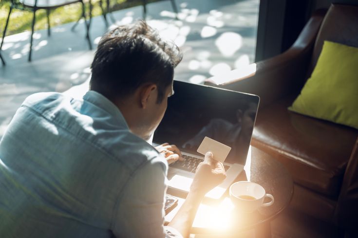 a man entering bank card details into a computer