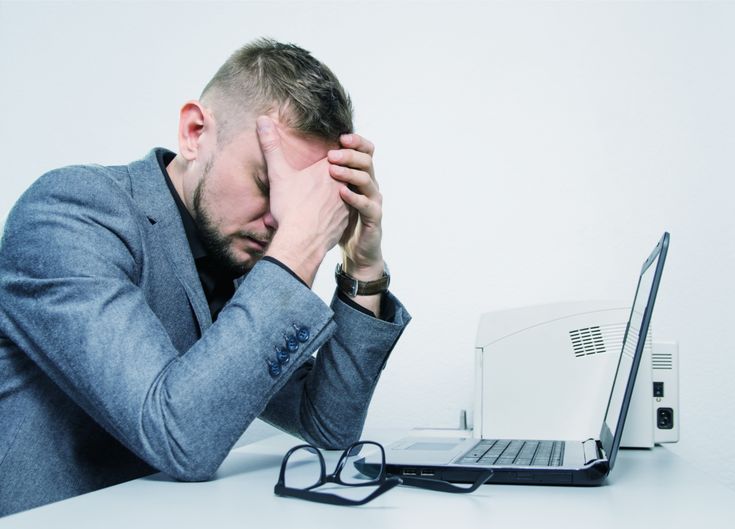 a man with his head in his hands after being scammed
