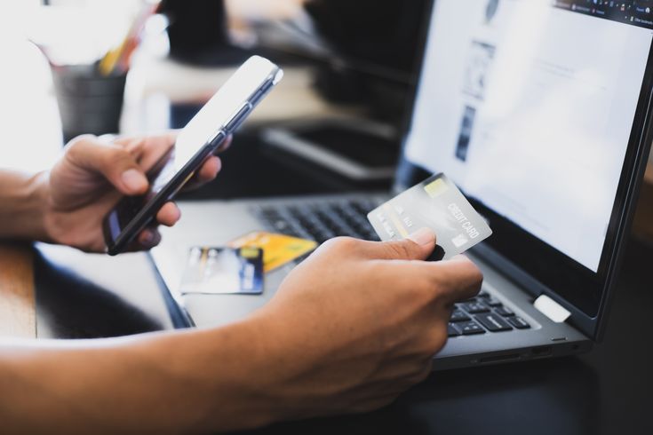 man inputting his card details into laptop